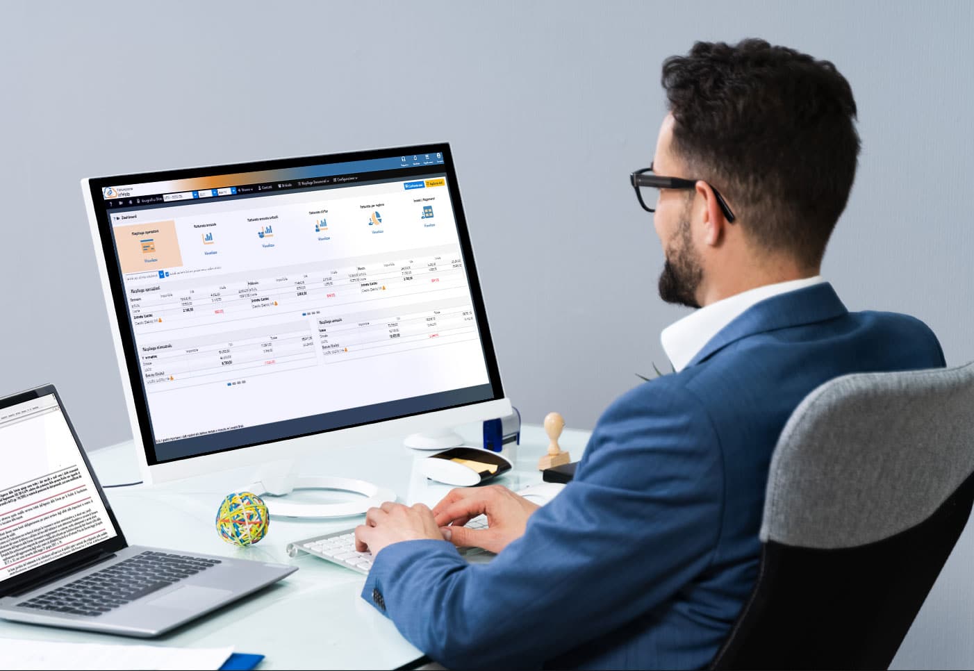 Software per commercialisti: professionista alla scrivania con i software GBsoftware su monitor e portatile